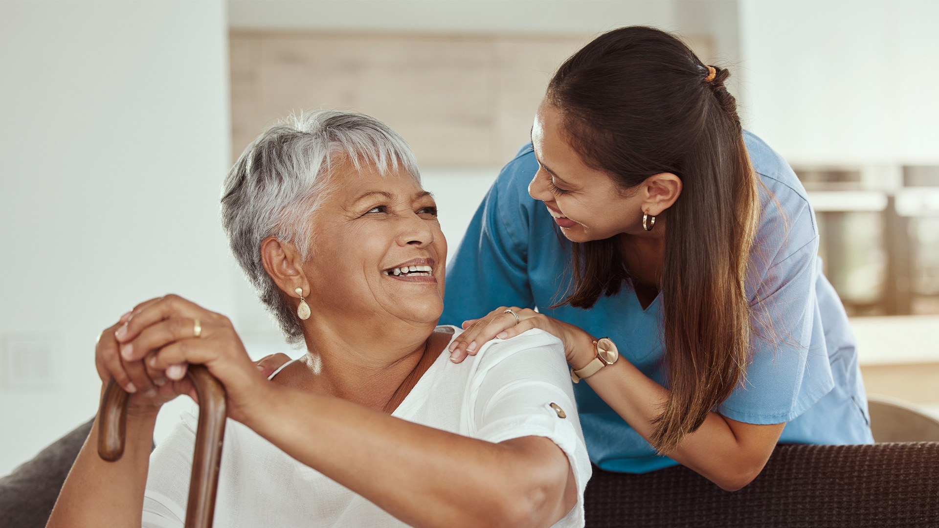 Kindhearted Nursing Solutions Fresno CA Happy, relax and senior woman with caregiver smile while sitting on a living room sofa 1